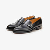 A pair of TLB Mallorca 325 Goya Buckled Loafers in Black Box Calf leather, shown at an angle to highlight the elegant buckle and sleek profile.