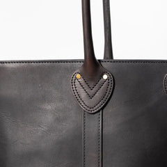 Close-up of the handle and hardware detailing showing solid construction, stitching precision, and durable metal fittings.