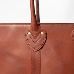 Close-up of the handle and hardware showing sturdy stitching and durable metal fittings.