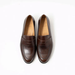 Top-down view of a pair of dark brown penny loafers showing the stitching detail and penny strap design of TLB 315 Jones Penny Loafer.