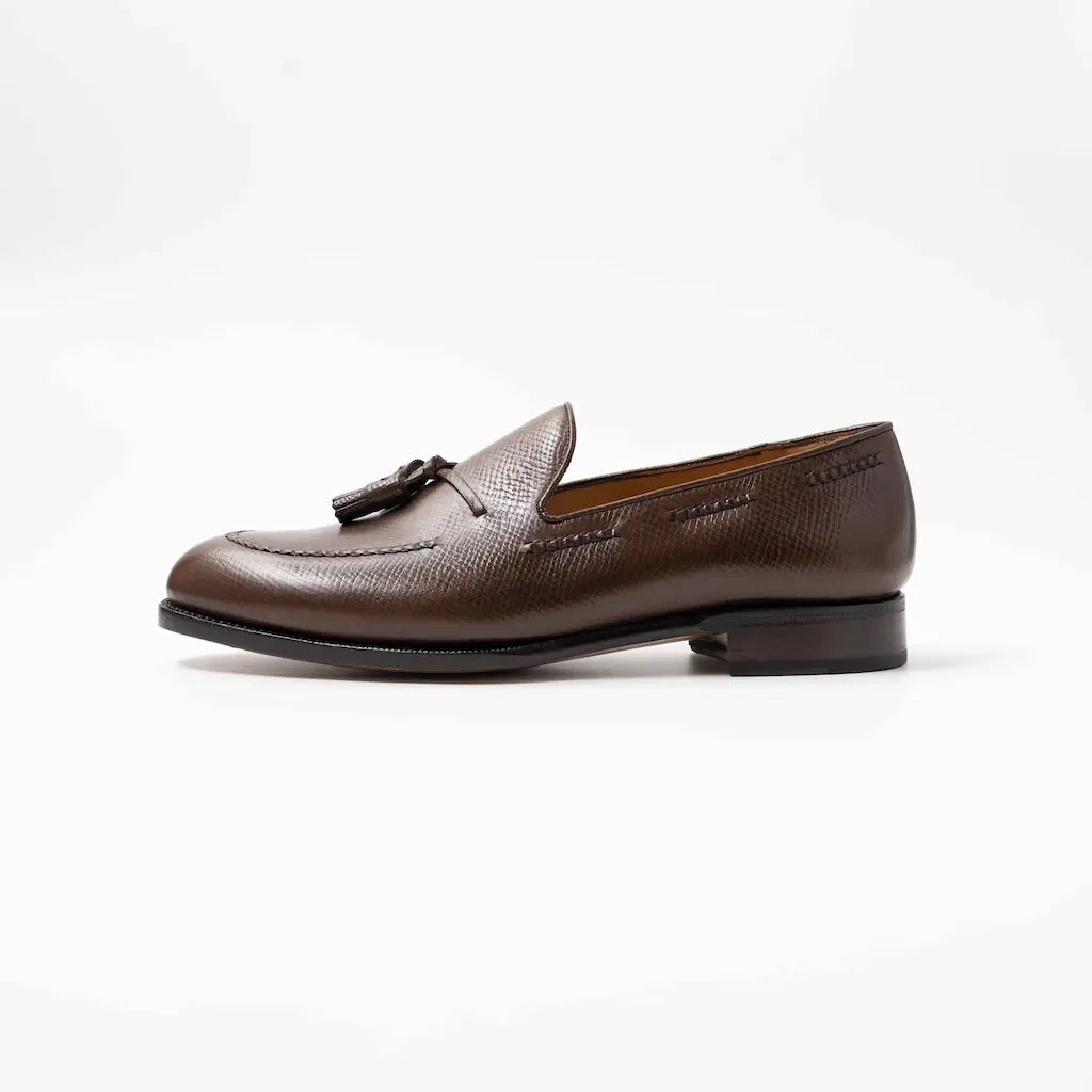Brown leather loafer with tassel on a white background