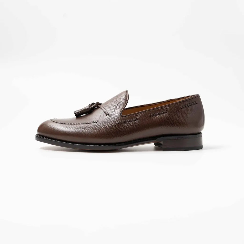 Brown leather loafer with tassel on a white background