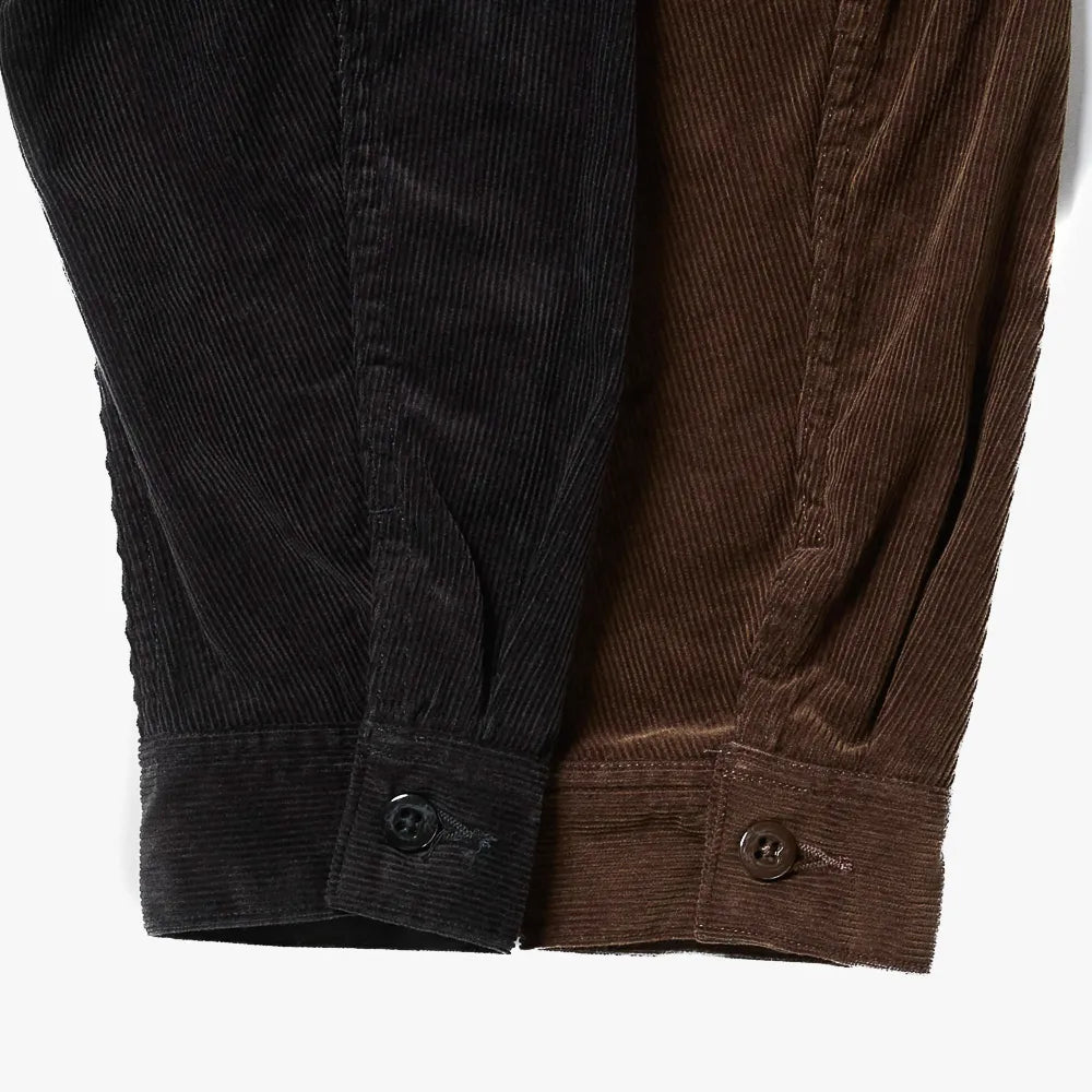 Close-up of the hem and pocket area showing stitching details and the wale texture of black corduroy.
