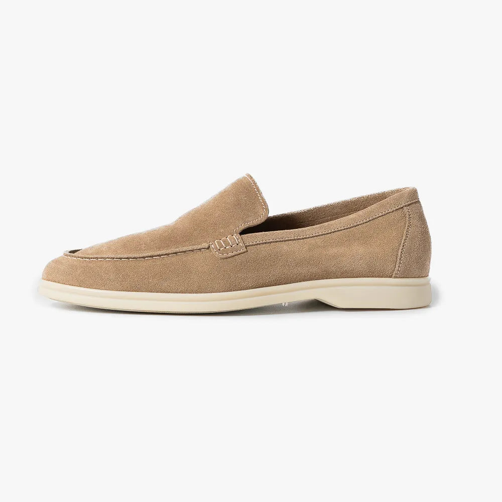 Side view highlighting the suede nap, flexible sole construction, and sleek loafer profile.