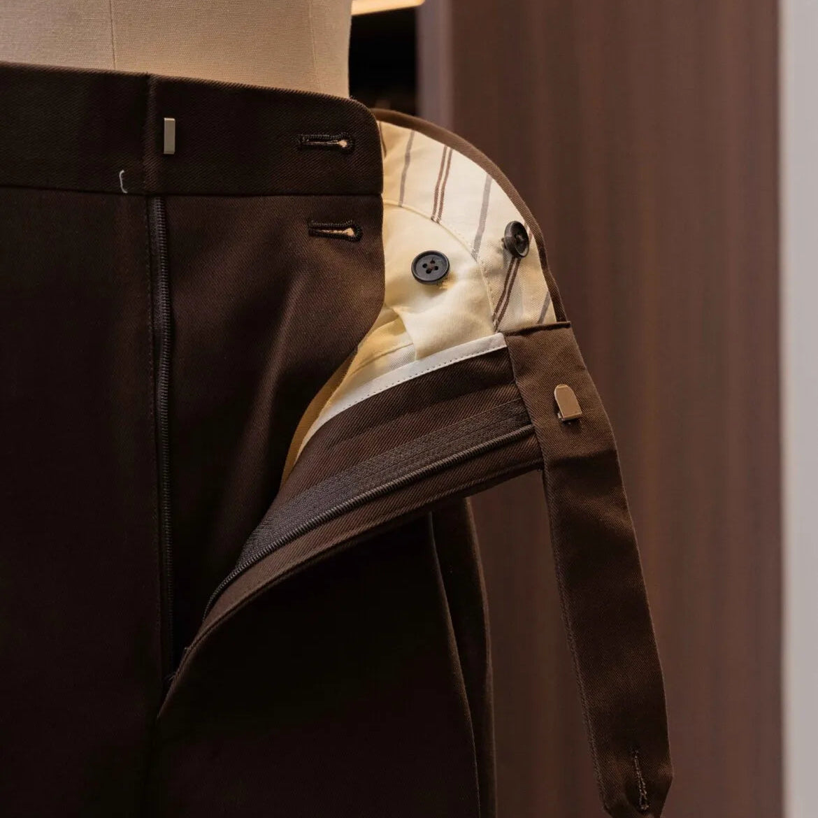 Close-up of the waistband button on the Calsa Nagasaki Trousers Cotton Dark Brown