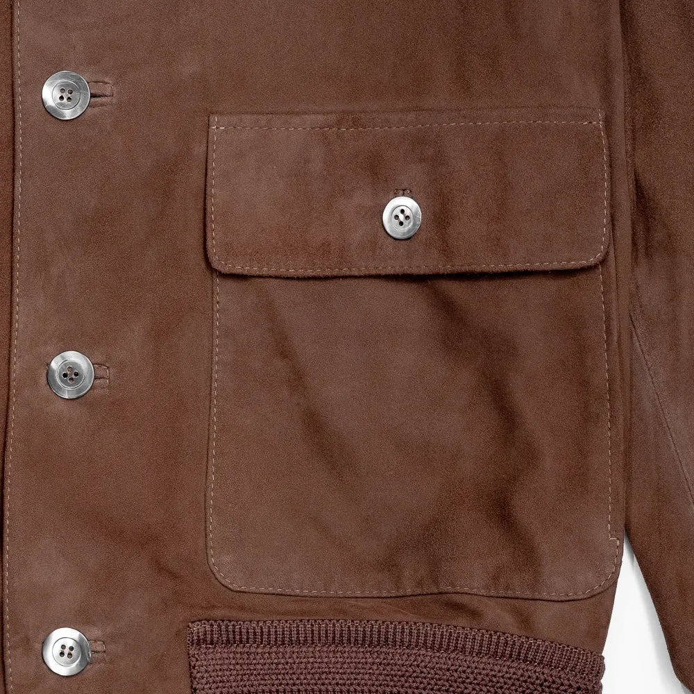Close-up of the welt pockets showing stitching precision, pocket opening structure, and suede grain.