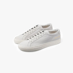 Full view of the Common Projects Achilles Premium 2572 in light grey showing the minimalist low-top silhouette and clean design.