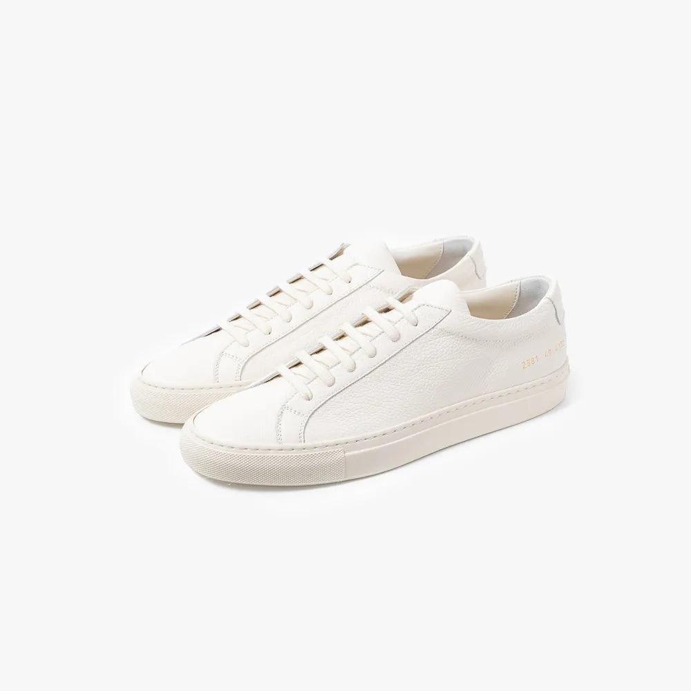 Full view of the Common Projects Achilles Premium Grained Leather 2581 in off white featuring a minimalist low-top silhouette and textured leather finish.