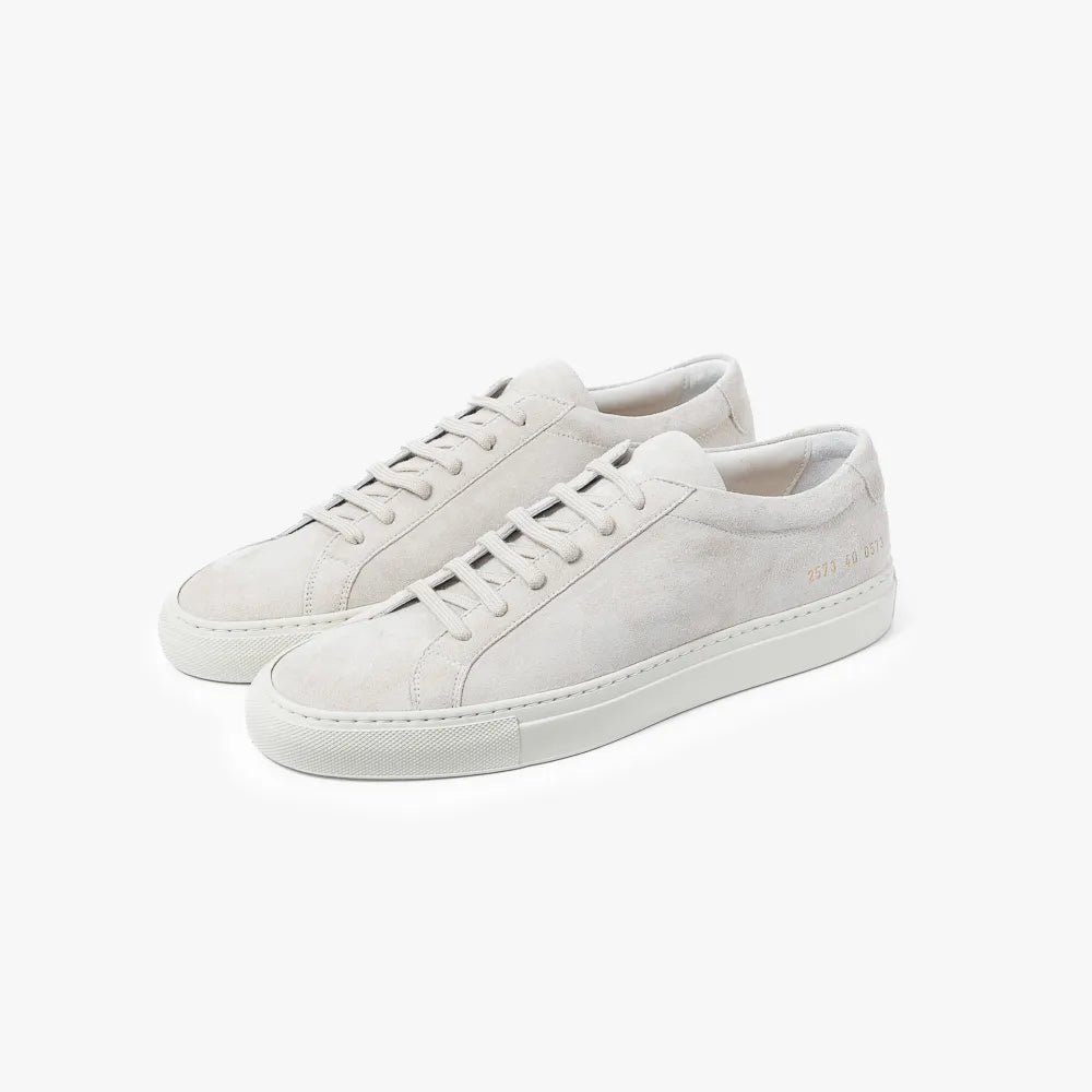 Full view of the Common Projects Achilles Premium in suede 2573 in light grey featuring a minimalist low-top silhouette and soft suede texture.