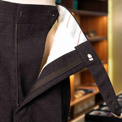 Close-up of the waistband and button area showing stitching, hardware, and precise tailoring.