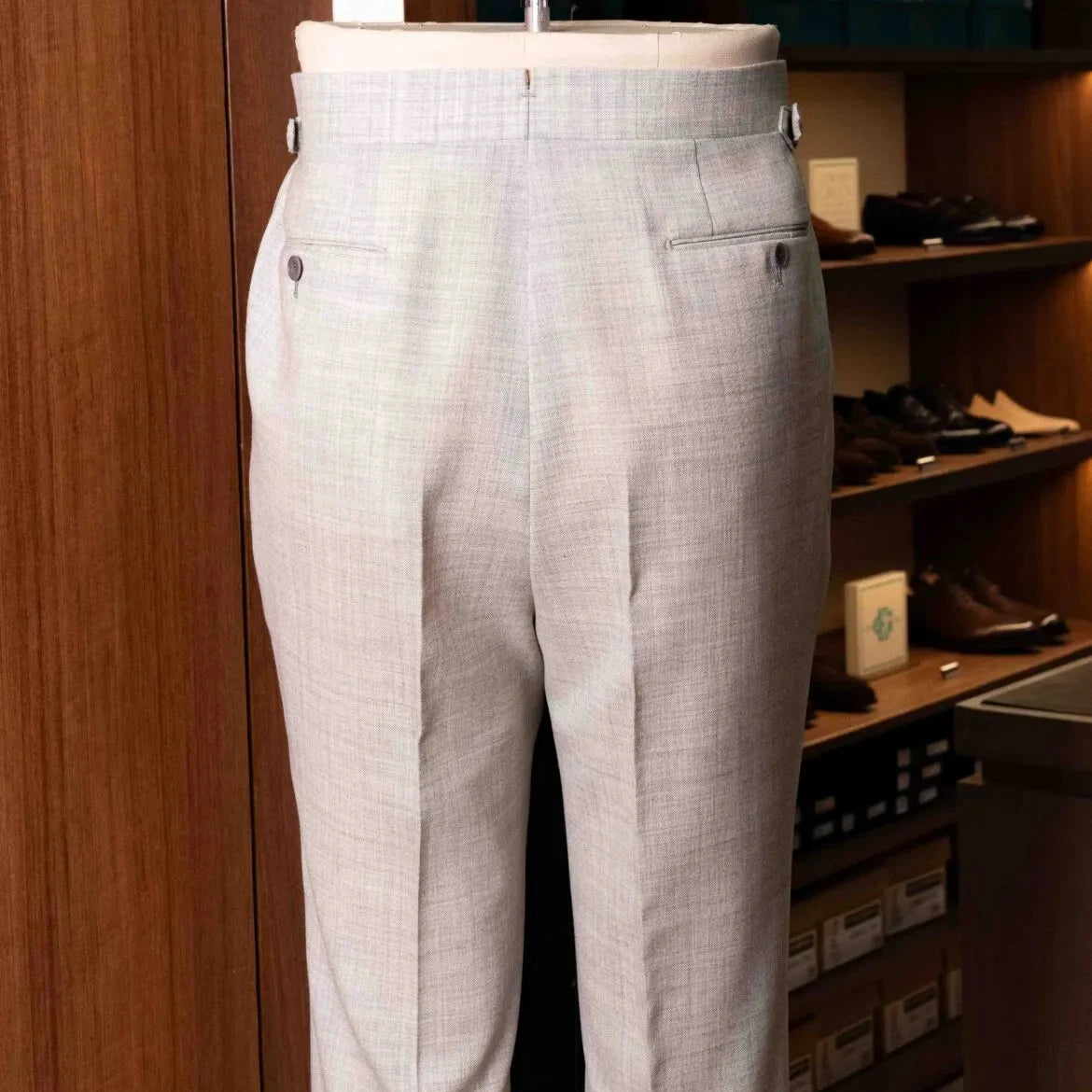 Back view of the Drummers Trousers Light Grey highlighting the back pockets, seam finishing, and structured drape.