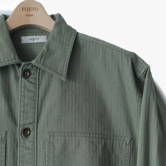 Close-up of the collar and button area showing stitching precision, button detail, and utilitarian shirt construction.
