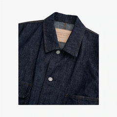 Close-up of the spread collar showing stitching precision and denim texture.