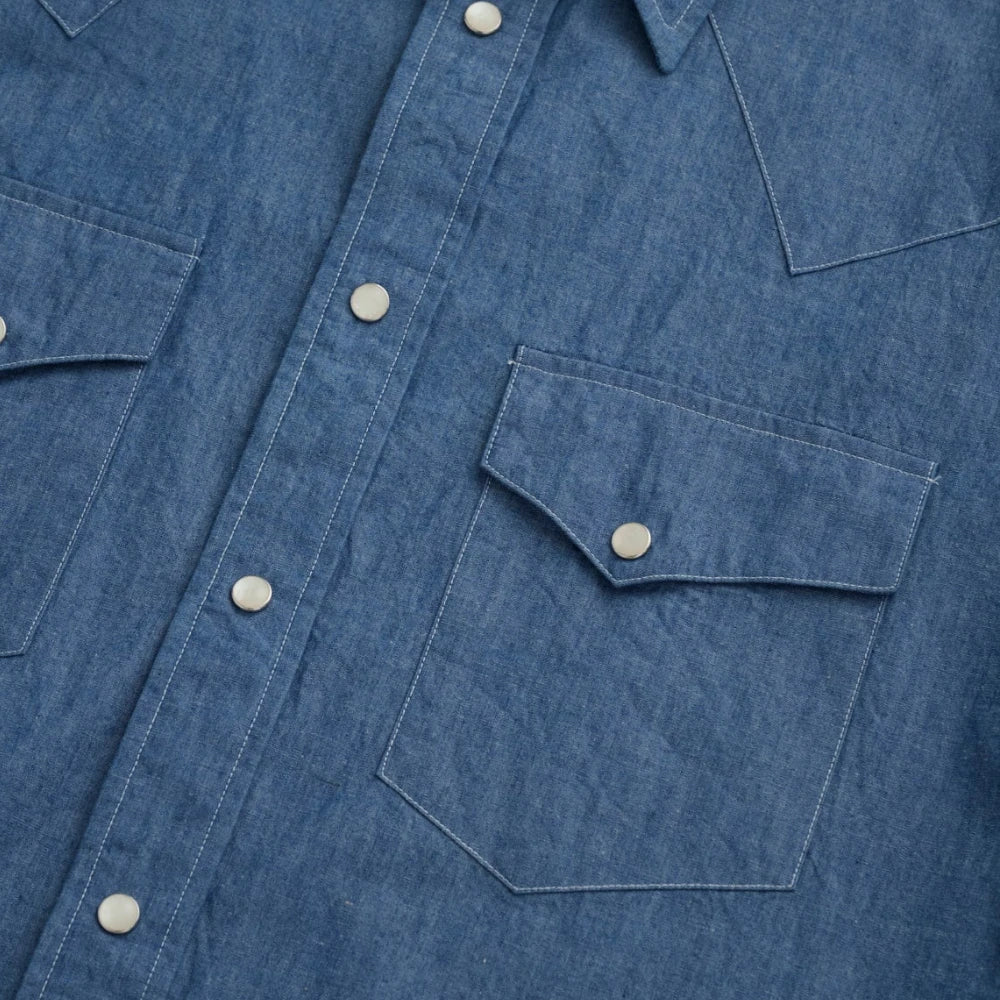 Close-up of the dual western chest pockets with pointed flaps and snap closures.