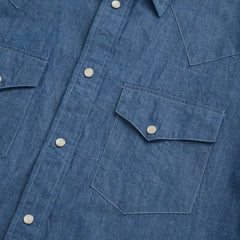 Close-up of the dual western chest pockets with pointed flaps and snap closures.