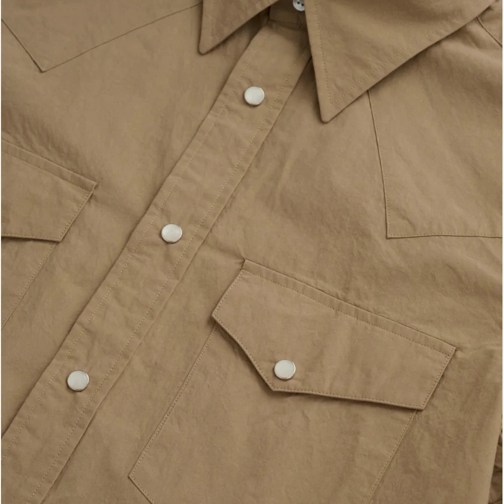 Close-up of the dual western chest pockets with pointed flaps and snap closures.