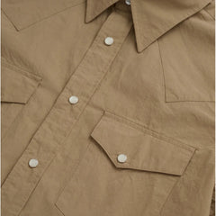 Close-up of the dual western chest pockets with pointed flaps and snap closures.