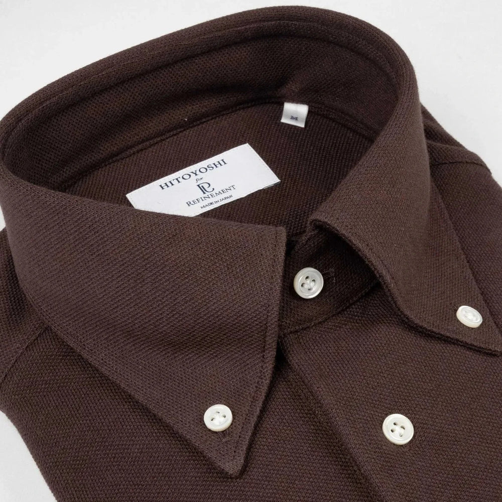 Close-up of the button-down collar showing roll shape, stitching precision, and refined textured knit in dark brown.