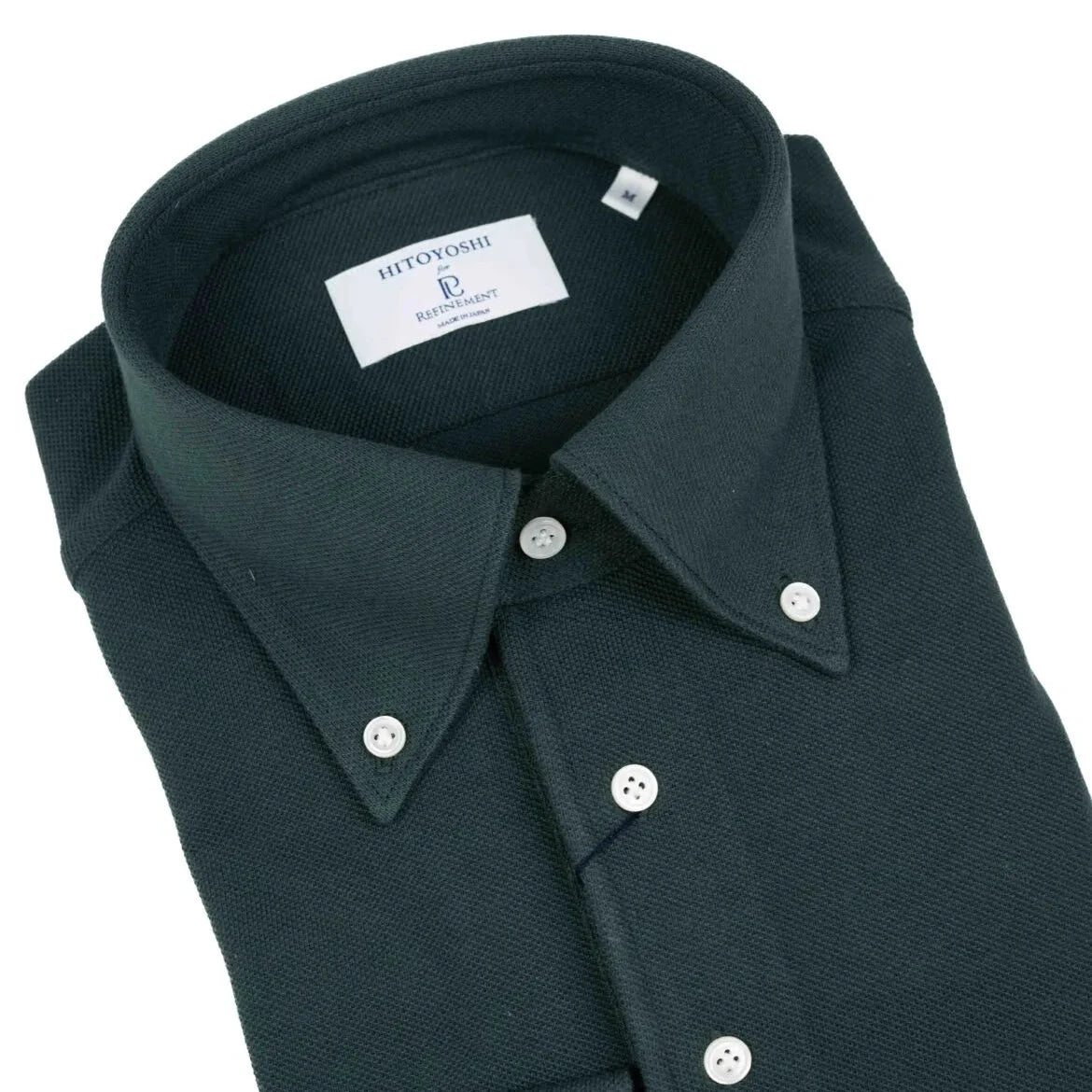 Close-up of the button-down collar showing roll shape, stitch precision, and textured dark green knit.