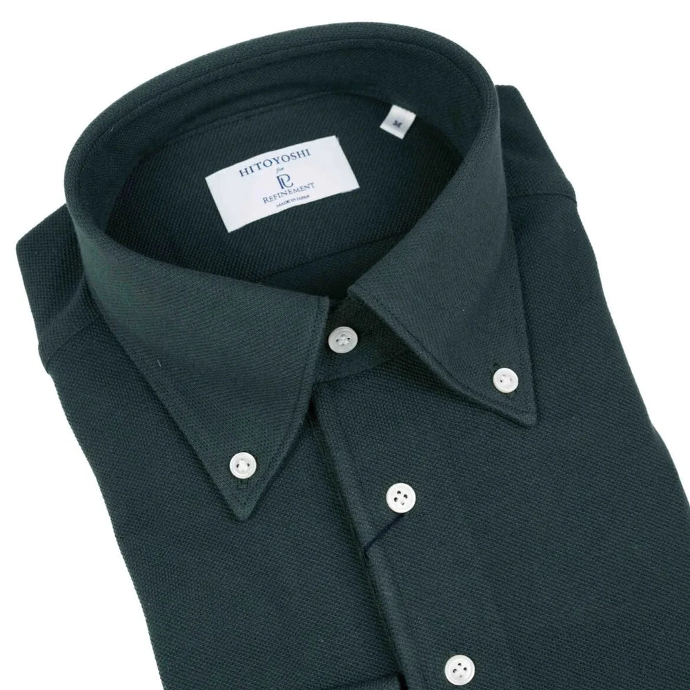 Close-up of the button-down collar showing roll shape, stitch precision, and textured dark green knit.