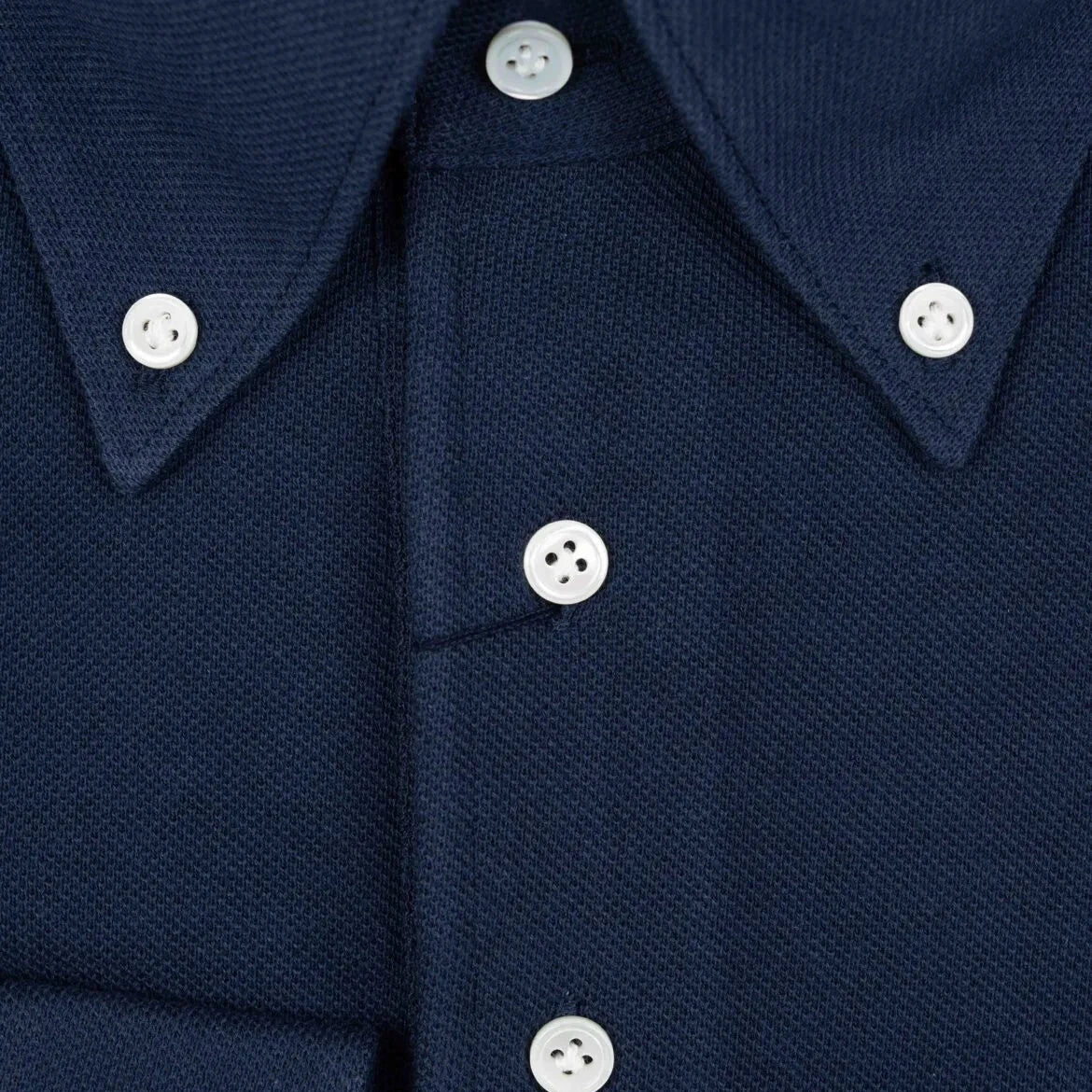 Close-up of the front placket showing button layout, knit density, and clean finishing.