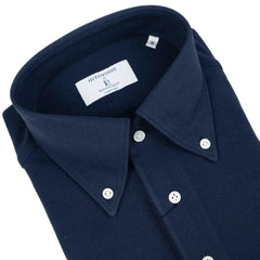 Close-up of the button-down collar showing roll shape, stitching precision, and refined knit texture.