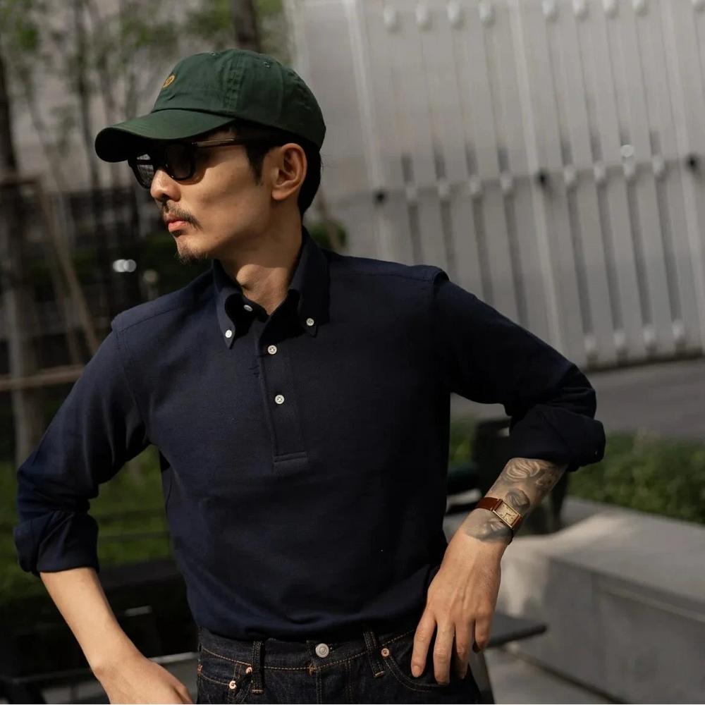 Side view showing sleeve length, shoulder structure, and soft drape of the navy knit fabric.