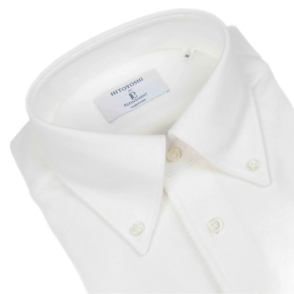Close-up of the button-down collar showing the roll shape, stitching accuracy, and soft knit texture in off white.