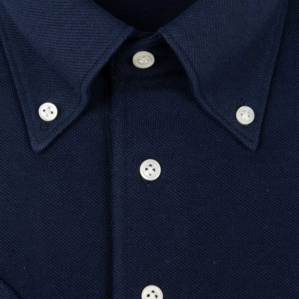 Close-up of the front placket showing button layout, knit structure, and clean finishing.
