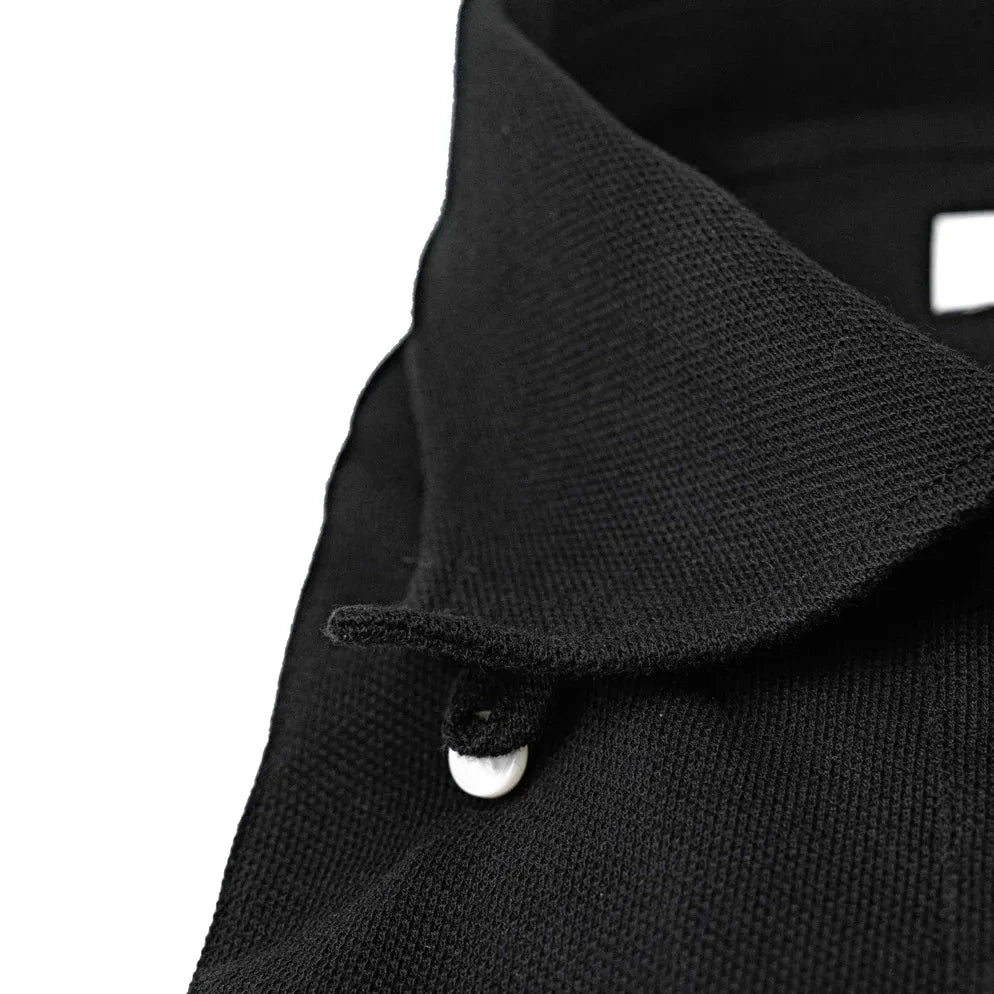 Close-up of the black knit fabric showing breathable texture, soft handfeel, and uniform deep-black coloration.