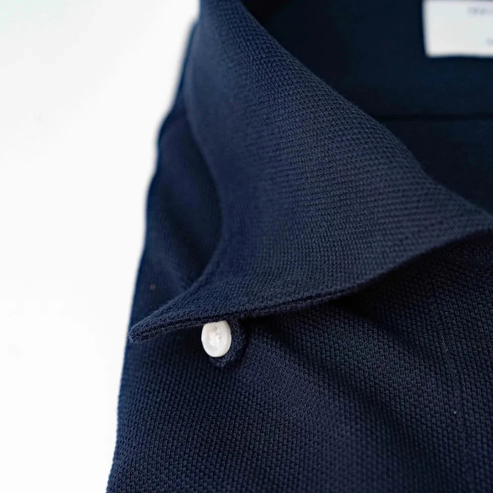 Close-up of the one-piece collar showing its seamless roll, precise shaping, and rich navy knit texture.