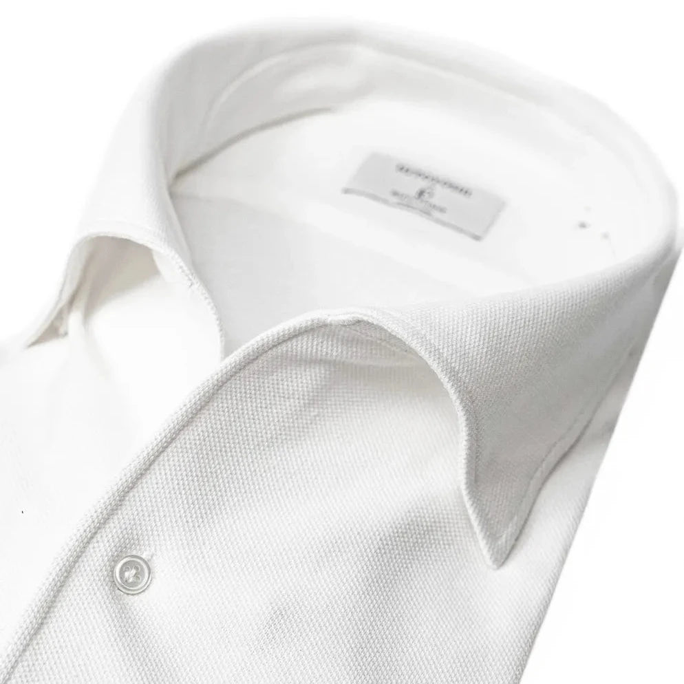 Close-up of the one-piece collar showing its seamless roll, refined shaping, and clean white knit texture.
