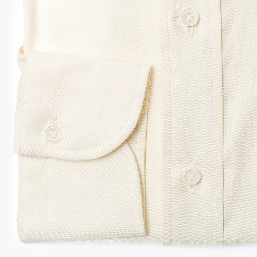 Close-up of the barrel cuff showing buttons, stitching, and smooth ivory fabric.