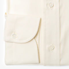 Close-up of the barrel cuff showing buttons, stitching, and smooth ivory fabric.