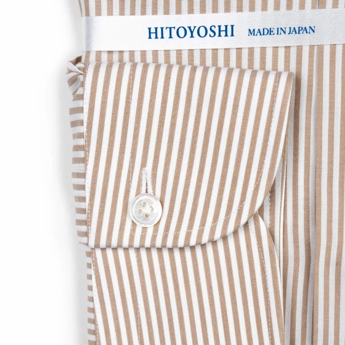 Close-up of the cuff showing stitching, button placement, and stripe continuation.