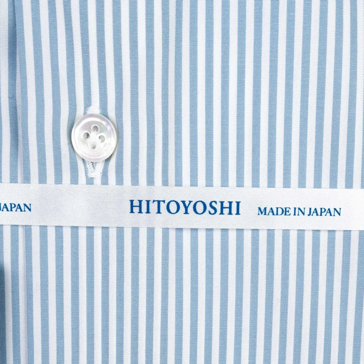 Close-up of the cuff showing button placement, stitching detail, and stripe continuation across the cuff.