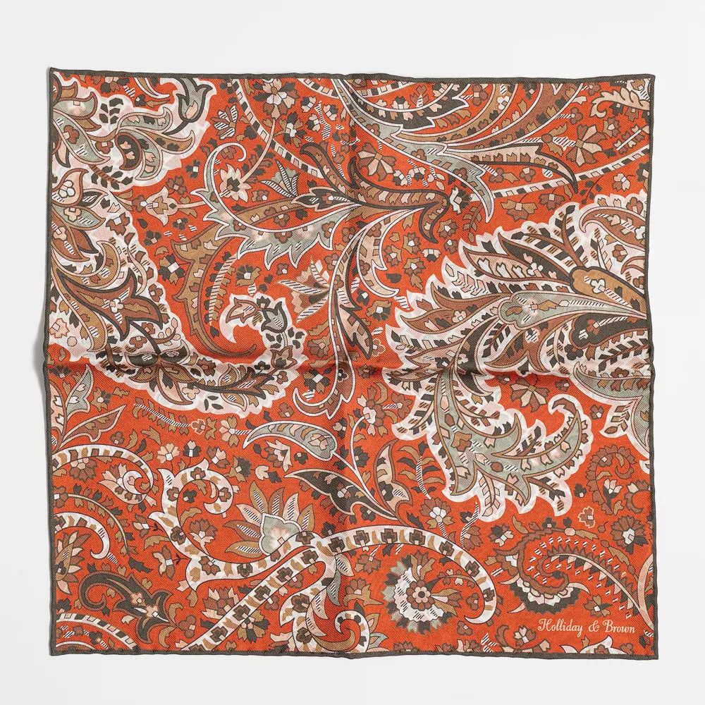 Full view of the Holliday & Brown paisley pocket square in green and brick showing elegant pattern and refined proportions.