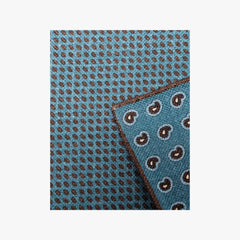 Close-up of the Holliday & Brown pocket square in blue paisley showing the fabric texture, drape, and intricate print work.