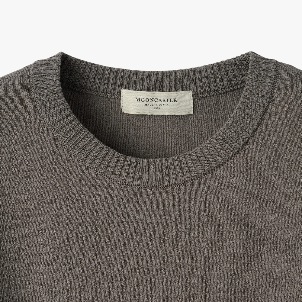 Close-up of the sleeve showing the knit texture and ribbed cuff detail.