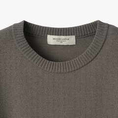 Close-up of the sleeve showing the knit texture and ribbed cuff detail.