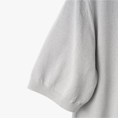 Close-up of the sleeve showing the knit texture and ribbed cuff detail.
