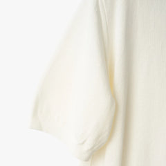 Close-up of the sleeve showing the knit texture and ribbed cuff detail.