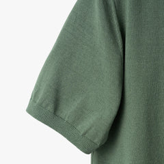 Close-up of the sleeve showing the knit texture and ribbed cuff detail.