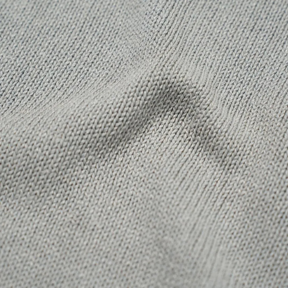 Close-up of the paper-silk blend fabric showing its ultra-light texture, subtle sheen, and soft light grey coloration.
