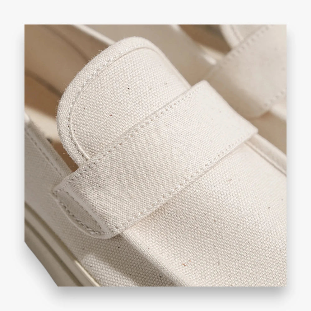 Close-up of the penny strap detail highlighting canvas texture and stitching.