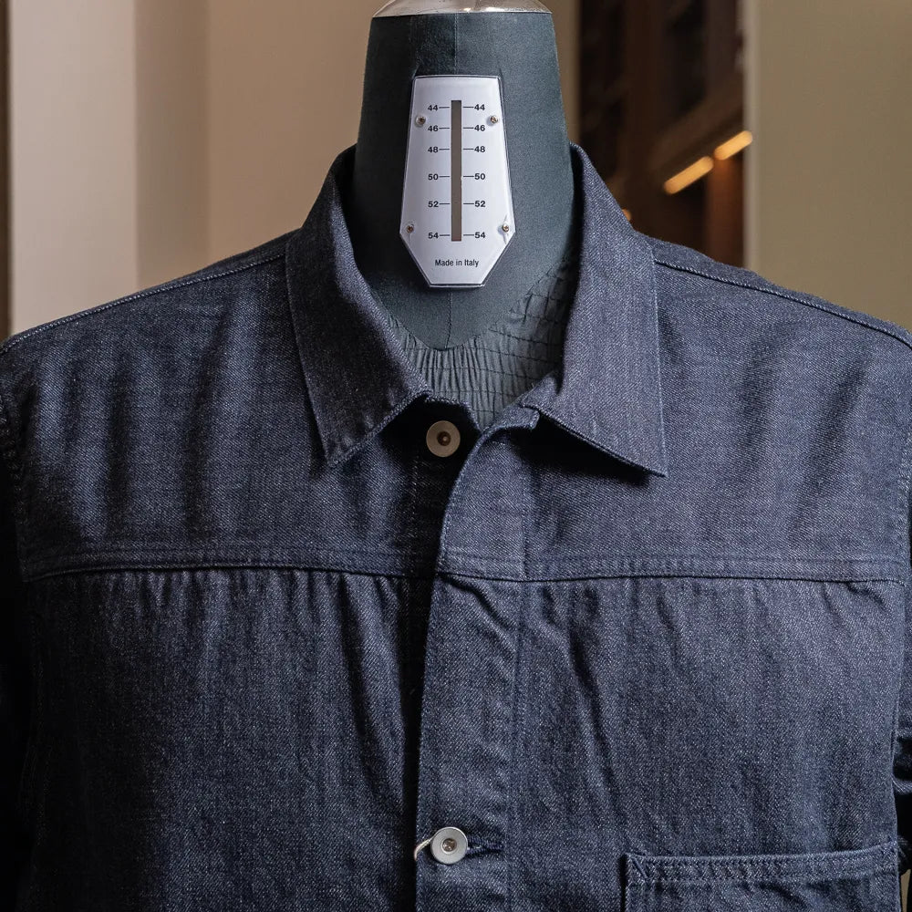 Close-up of the collar and upper chest highlighting indigo denim texture and front button fastening.