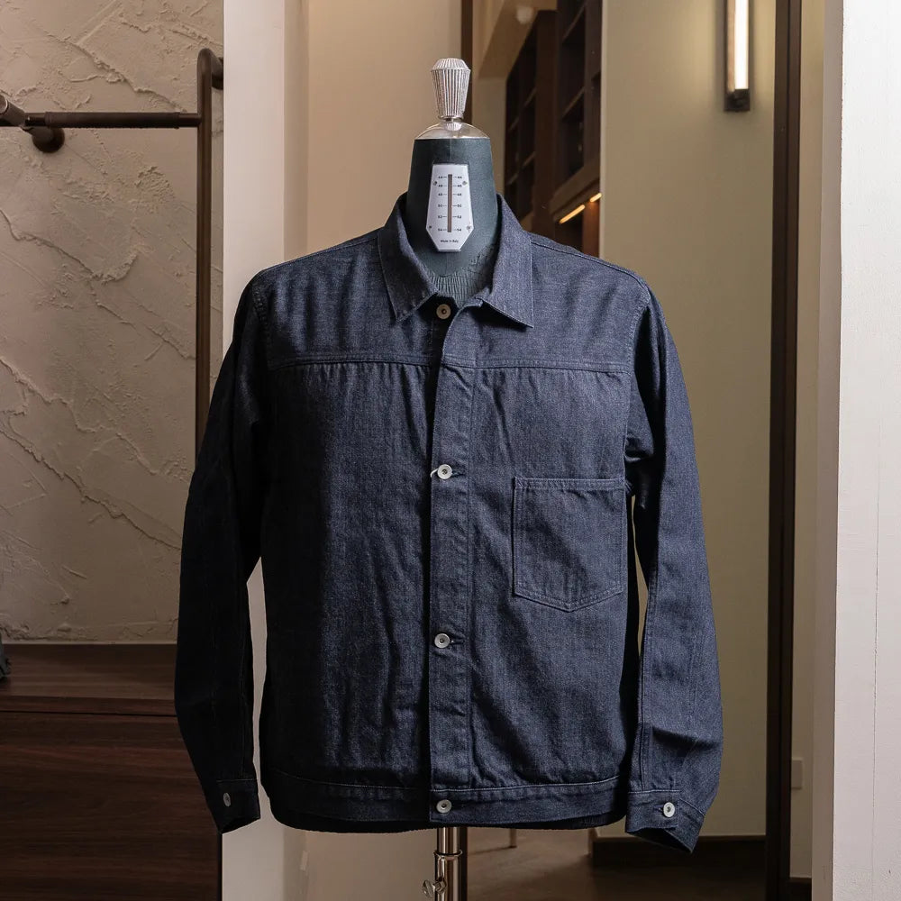 Front view of the Nanamica Short Denim Jacket in indigo featuring a cropped silhouette and clean structured design.
