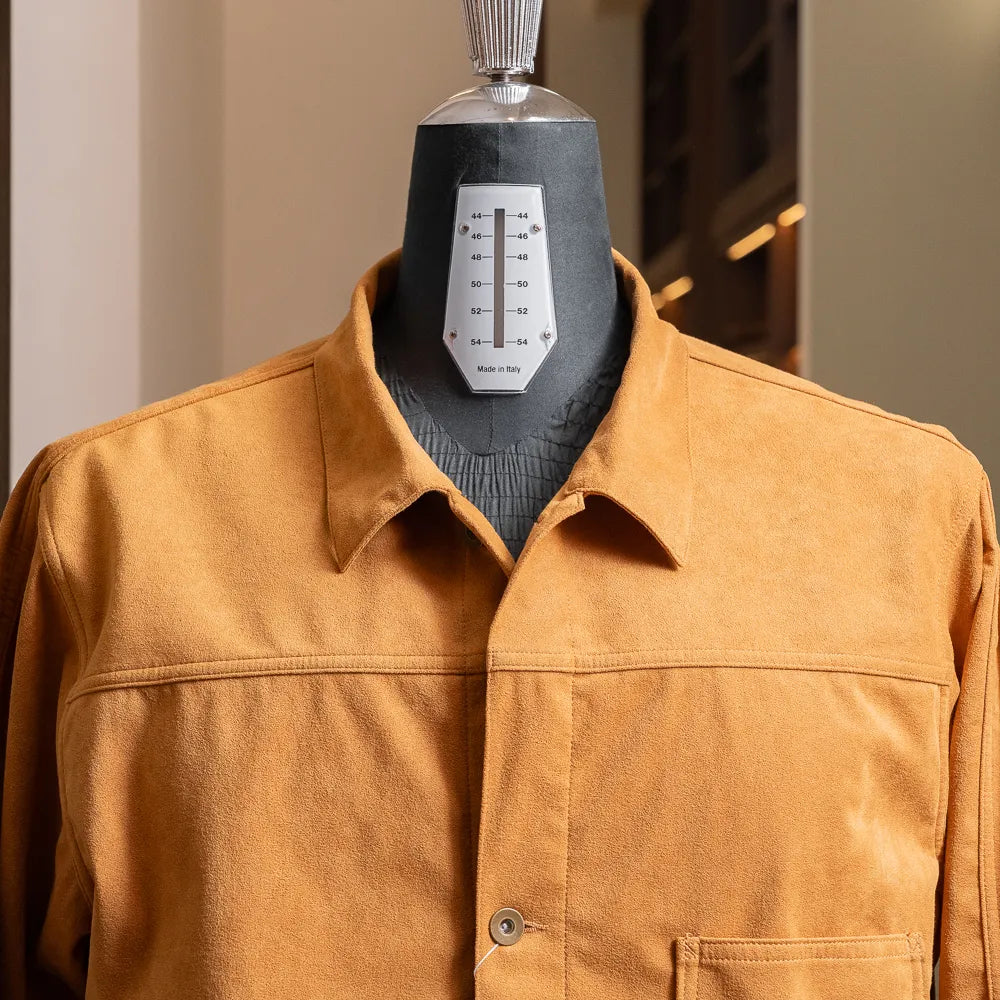 Close-up of the collar and upper chest showing smooth synthetic leather texture and button closure.