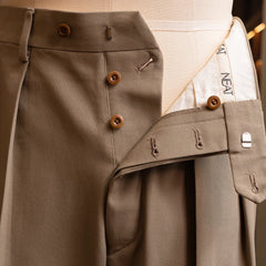 Close-up of the front fly and inner waistband construction showing button fastening and interior finishing.
