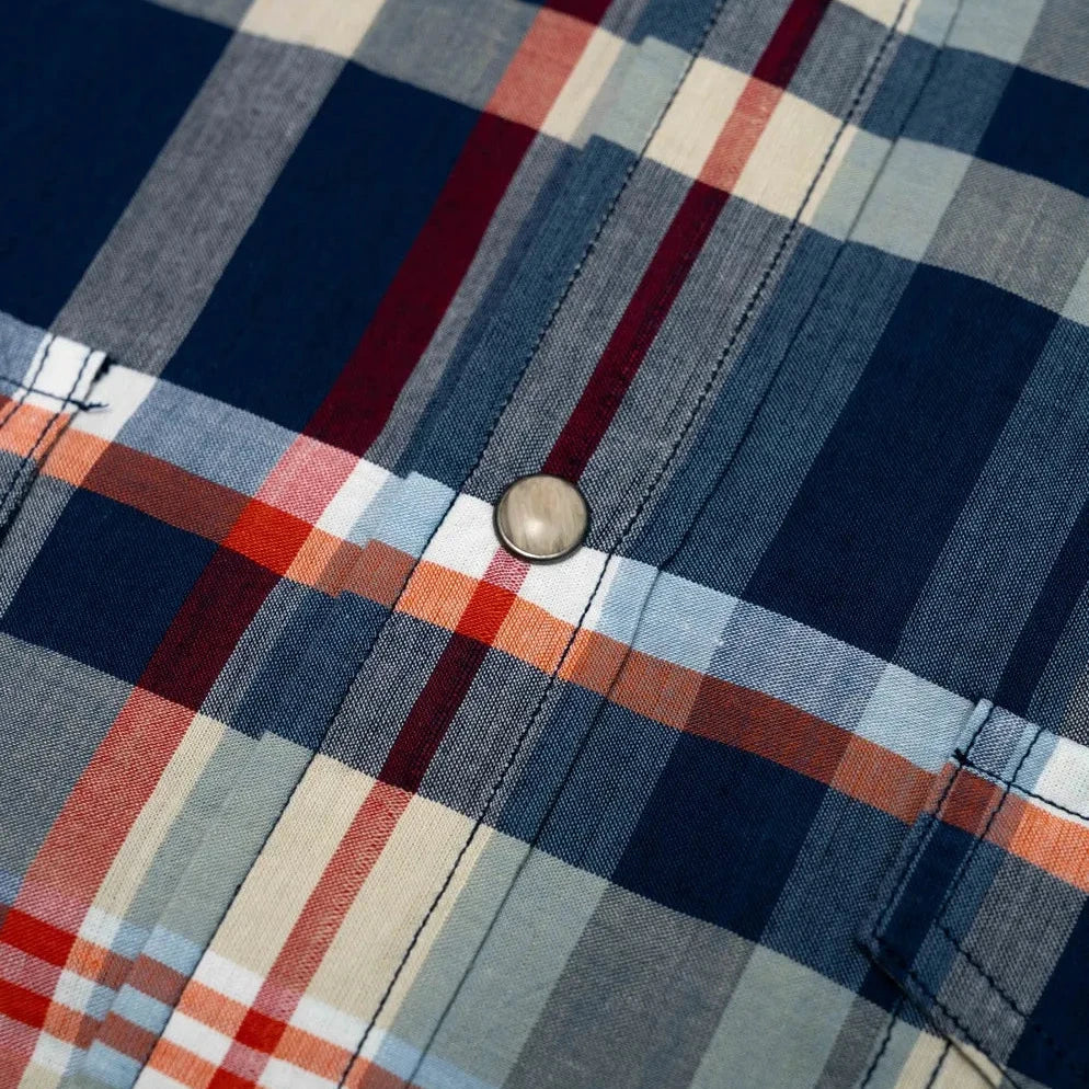 Close-up of the navy–red checked Madras fabric showing handwoven texture, weave irregularities, and breathable cotton feel.